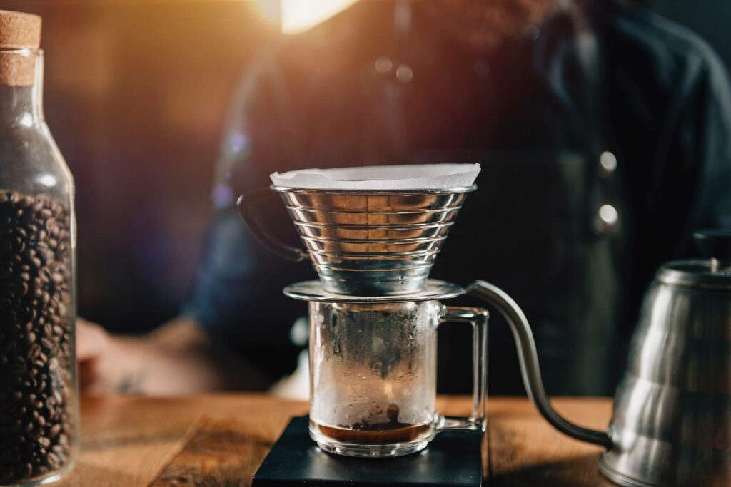 Close up Kalita Wave Dripper on black digital scale, wooden table. Tools and equipment for making Drip Brew coffee